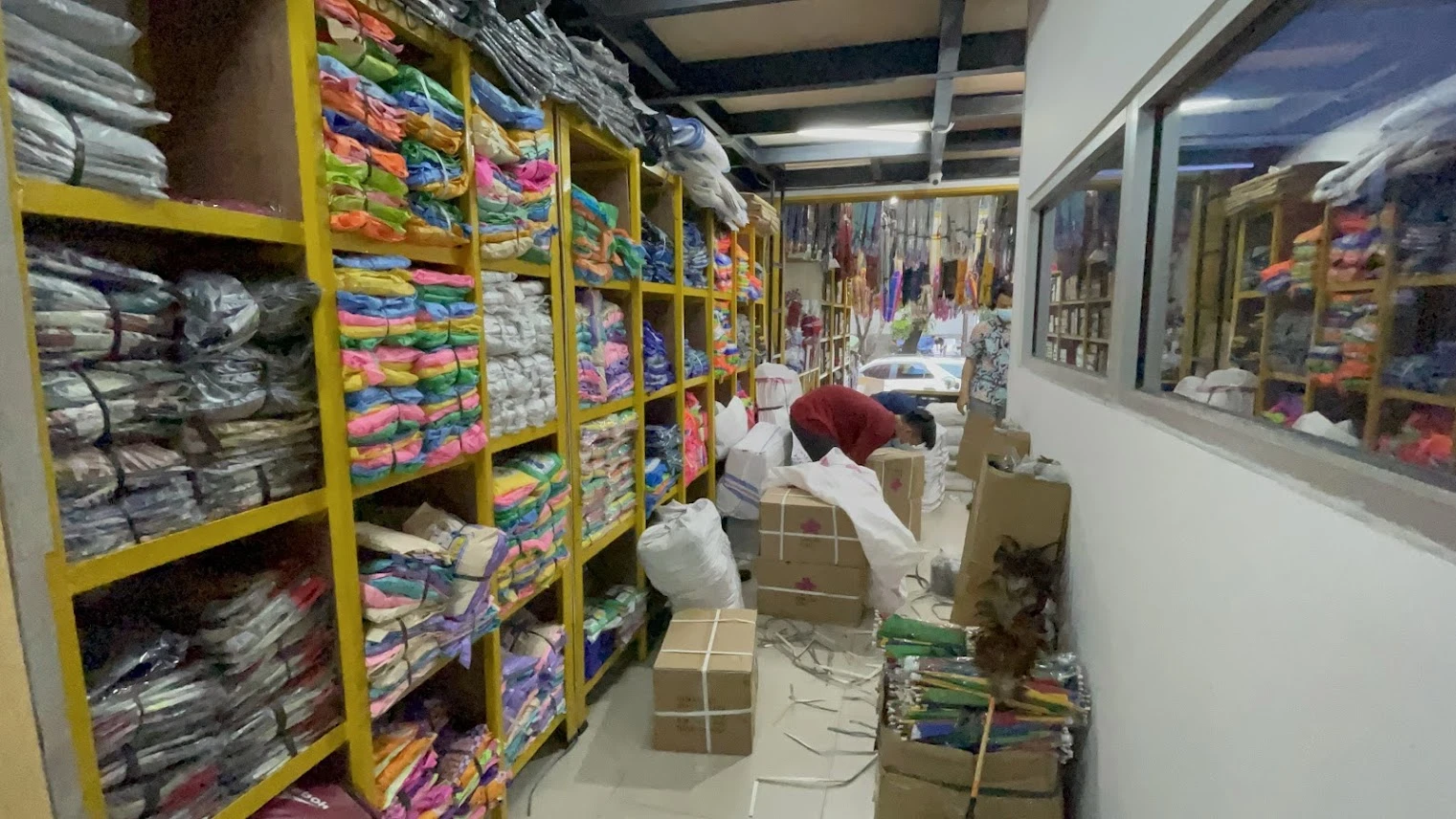 Area stok Toko Istana Payung — rak penuh payung dan jas hujan siap kirim